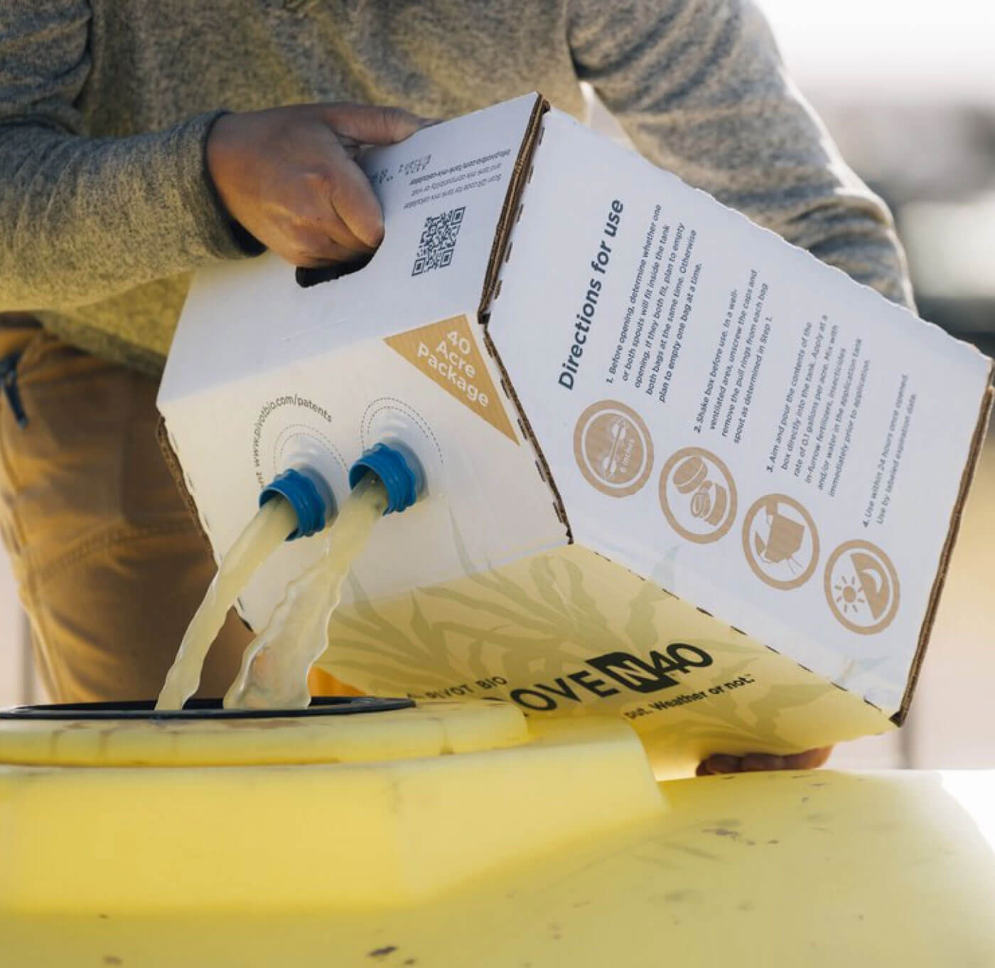 Farmer pouring Pivot Bio Proven40 product into their tanks